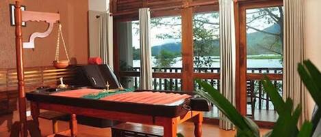 A pool table in a room with large windows and a view of a deck and mountains.