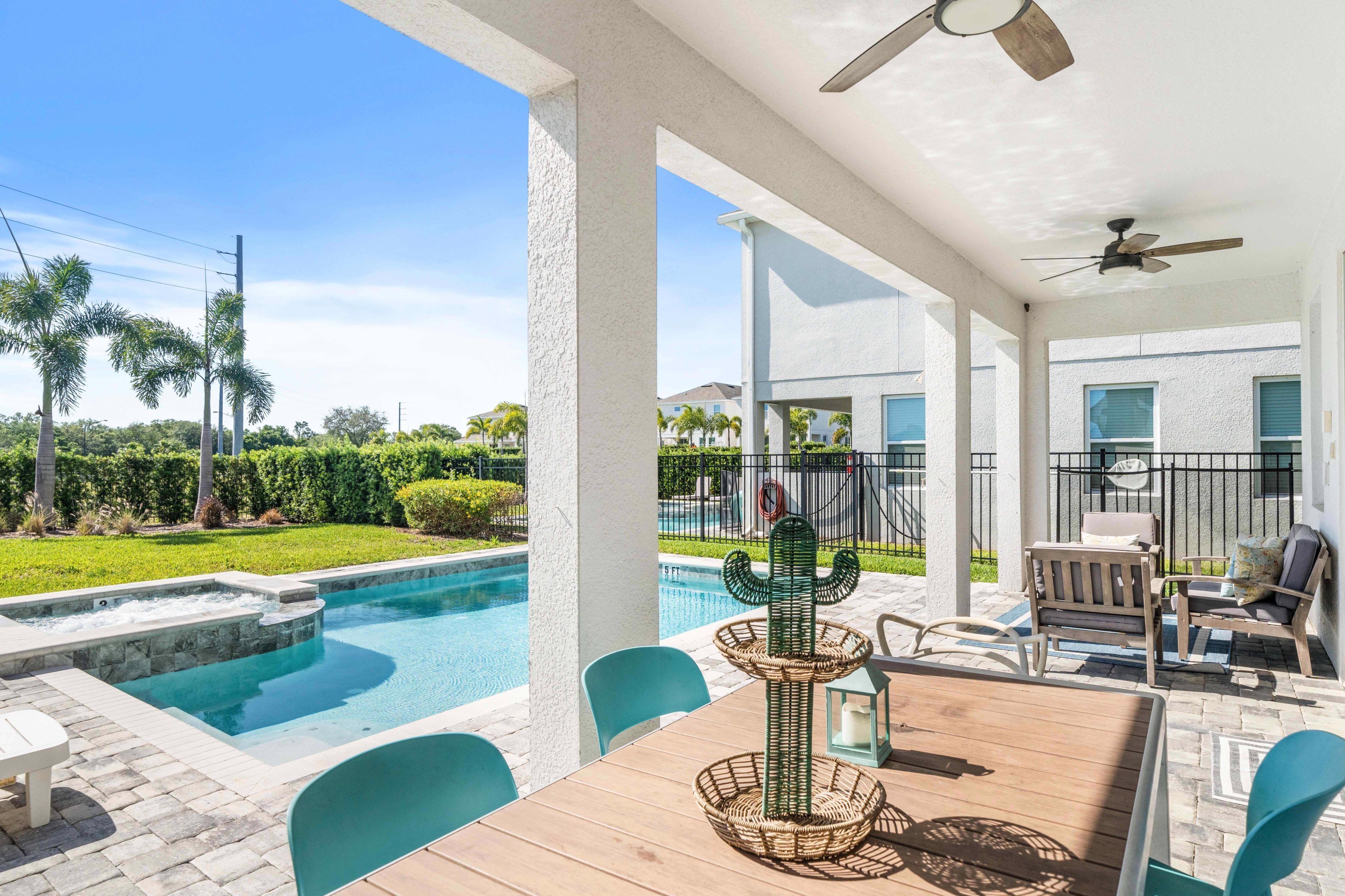 A covered patio with a pool, outdoor seating, and a cactus centerpiece.