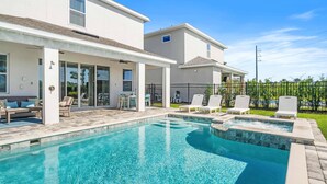 A swimming pool with lounge chairs and a covered patio area. - Modern Family Villa Close To Disney With Private Pool (Kissimmee)