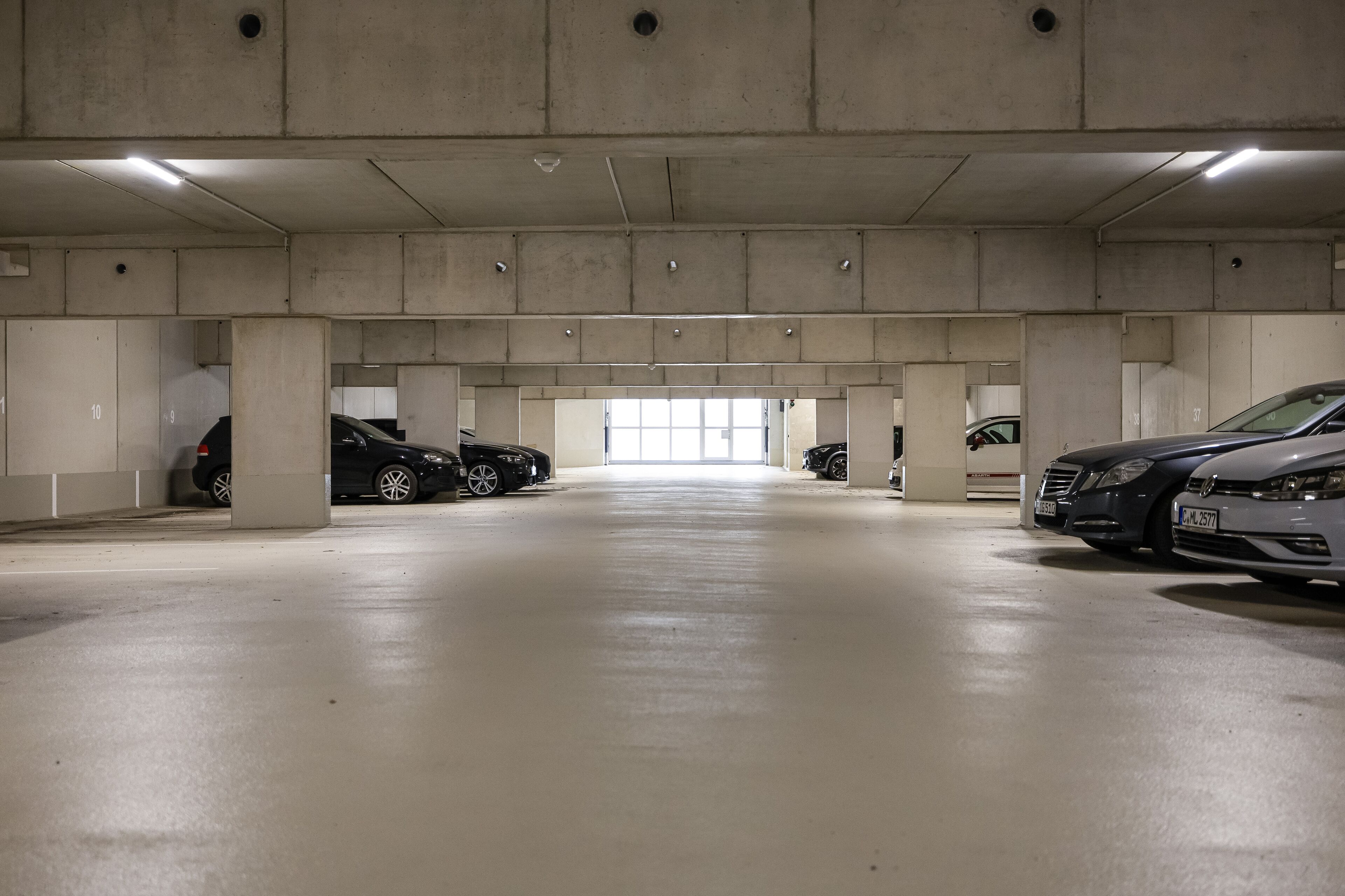 A multi-level parking garage with concrete pillars and a clean, well-lit floor.