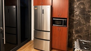 Una cucina con un frigorifero nero, un forno in acciaio inossidabile e un microonde.