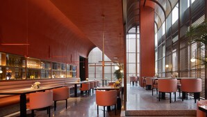 A modern restaurant with high ceilings, large windows, and a variety of seating options including booths and tables. - Hampton by Hilton Shenzhen Science Park (Shenzhen)