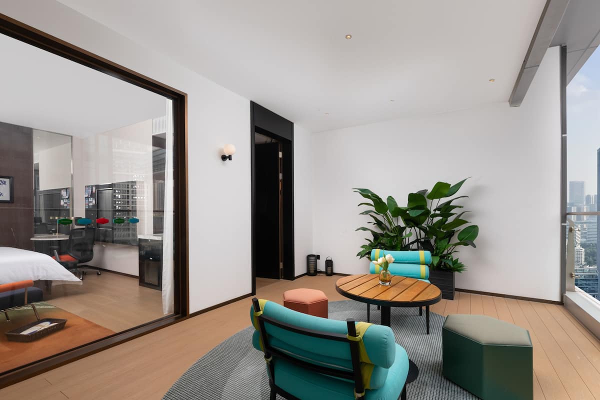 Un salon moderne avec un canapé, une petite table et une plante en pot.