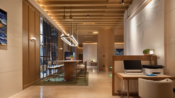 A modern hotel lobby with a wooden ceiling, a reception desk, and a seating area with chairs and tables. - Hampton by Hilton Shenzhen Science Park (Shenzhen)