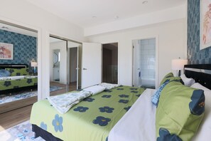 Un dormitorio con una cama grande, un espejo y una puerta que da a otra habitación.