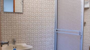 Een douche, handdoeken, zeep, toiletpapier