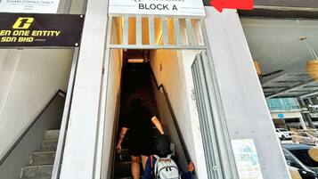 A staircase leading to a block labeled 'BLOCK A' with a sign for 'METROCITY B&CKPACKERS'.