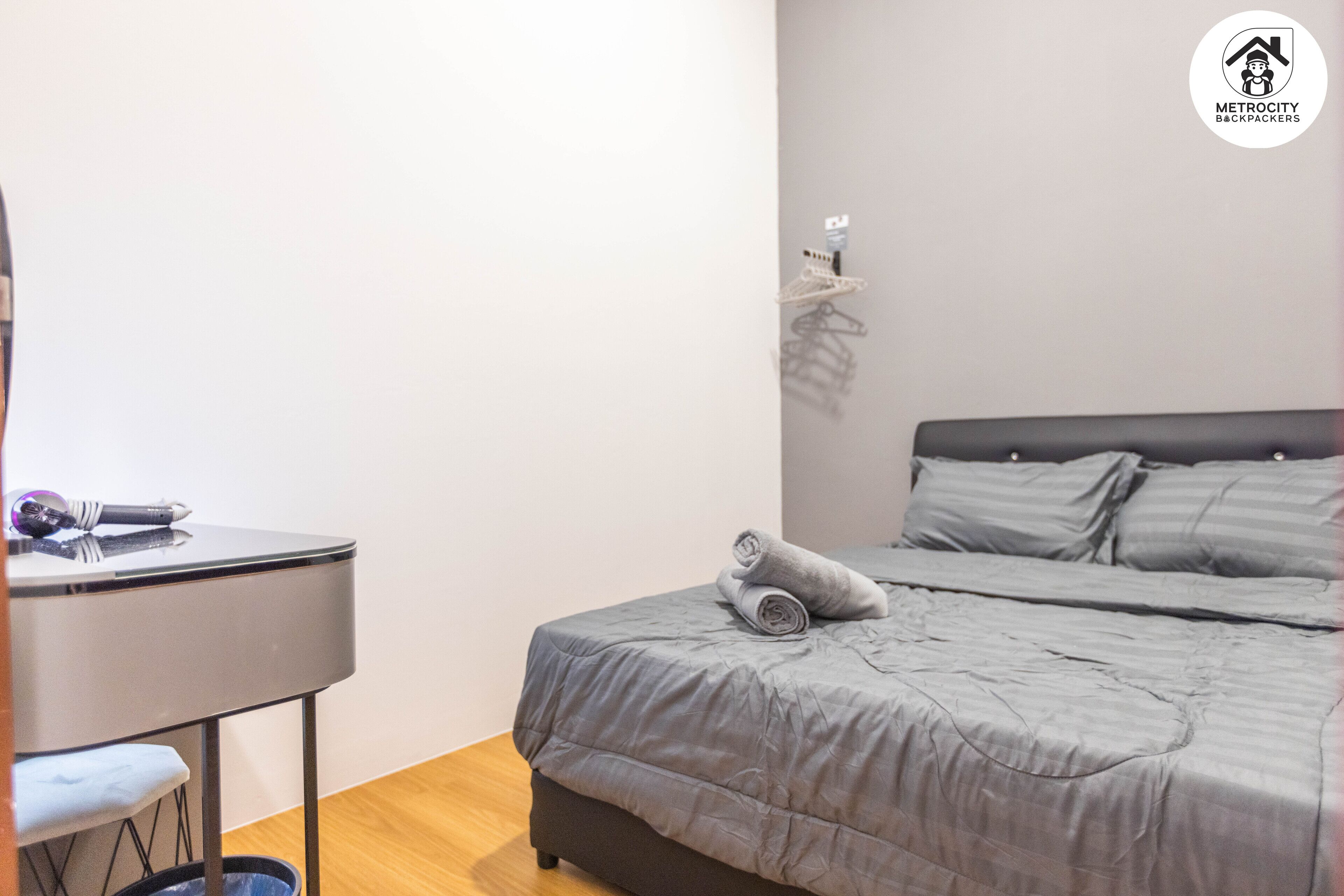 A neatly arranged bedroom with a bed, a small table, and a chair.