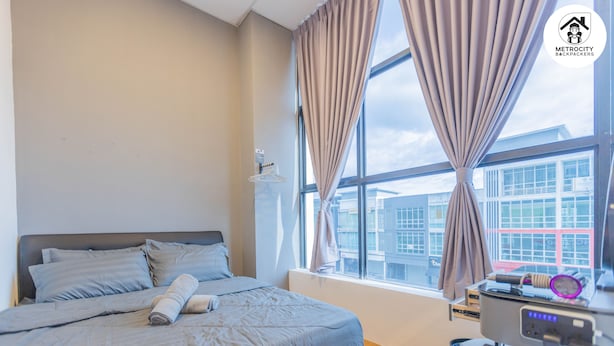 A modern hotel room with a large bed, a desk with a computer, and a window with curtains. - MetroCity Backpackers (Kuching)