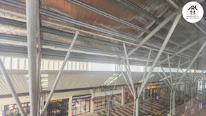 An indoor shopping area with a high ceiling and metal beams, featuring stores like 'Daddy Vape' and 'Burger Bar'. - MetroCity Backpackers (Kuching)