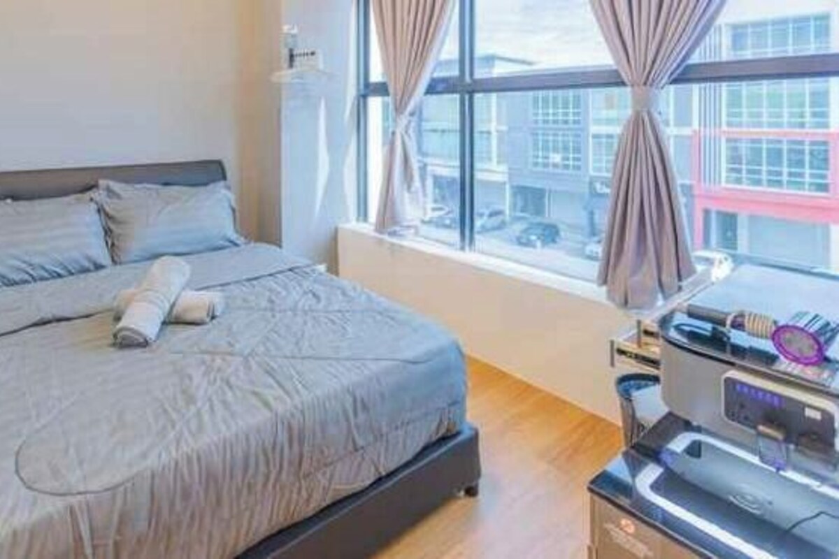 A hotel room with a bed, a window with curtains, and a desk with a printer.