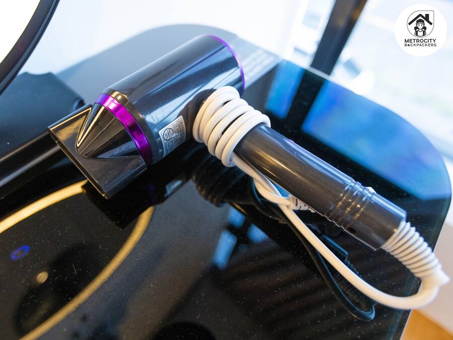 A charging station with a purple light indicator and a white cable connected to a device.
