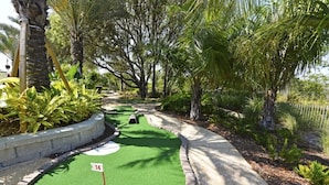 A miniature golf course with a green putting area, numbered hole 14, surrounded by trees and shrubs. - Fs4004ha - 5 Bedroom Townhome In Festival Resort, Sleeps Up To 10, Just 7 Miles To Disney (Davenport)