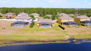 Un quartier résidentiel avec des maisons, des piscines et un lac.