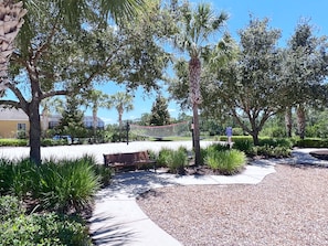 A pathway lined with trees and a bench, leading to a building with a glass facade. - Fs4006ha - 5 Bedroom Villa In Watersong, Sleeps Up To 10, Just 9 Miles To Disney (Davenport)