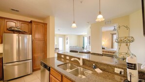 A modern kitchen with stainless steel appliances, granite countertops, and wooden cabinetry. - It289 - 3 Bed Condo in Vista Cay Resort, Sleeps Up To 6, Just 7 Miles To Disney (Orlando)