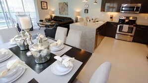 A modern kitchen with dark cabinets, stainless steel appliances, and a central island. - It2561 - 3 Townhome in Serenity, Sleeps Up To 7, Just 5 Miles To Disney (Clermont)