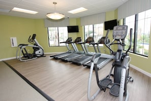 A gym with treadmills, ellipticals, and a stationary bike.