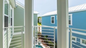A view of a residential area with houses, a pool, and a clear sky.