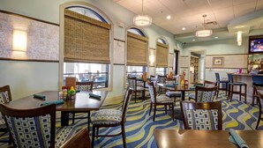 A restaurant with round tables, patterned chairs, and a blue and yellow carpet. - Grh9372ha - Champions Gate Resort - 5 Bed 4 Baths Villa (Davenport)