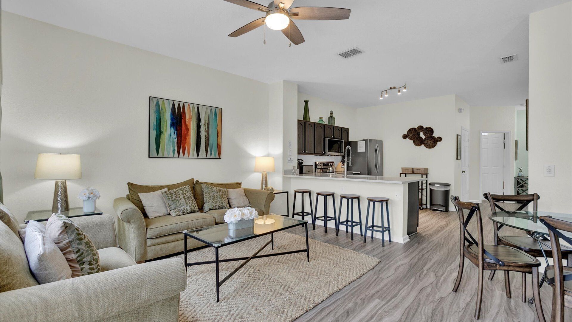 A modern living room with a sofa, coffee table, and a kitchen area with bar stools.