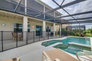 A covered outdoor swimming pool area with lounge chairs and a patio table, surrounded by a fence. - Fs9534ha - The Shire at West Haven - 5 Bed 4 Baths Villa (Davenport)