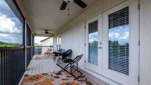 A covered porch with a ceiling fan, a table with chairs, and a decorative rug. - Fs9534ha - The Shire at West Haven - 5 Bed 4 Baths Villa (Davenport)