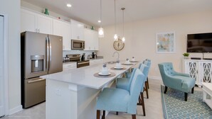 A modern kitchen with white cabinets, stainless steel appliances, and a central island with seating. - Fs9554ha - Storey Lake Resort - 4 Bed 3 Baths Townhouse (Kissimmee)
