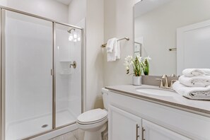 A modern bathroom with a glass-enclosed shower, a white toilet, and a vanity with a sink and mirror. - Fs9665ha - Champions Gate Resort - 4 Bed 3 Baths Townhouse (Davenport)