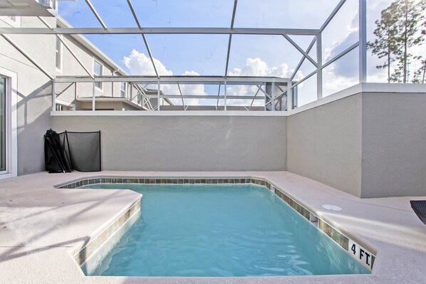 A swimming pool with a 4 ft depth marker, surrounded by a covered patio area with a glass ceiling. - Fs9665ha - Champions Gate Resort - 4 Bed 3 Baths Townhouse (Davenport)