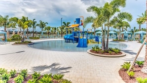 A pool area with a blue play structure, palm trees, and lounge chairs. - Fs9729ha - Solara Resort - 9 Bed 6.5 Baths Villa (Kissimmee)