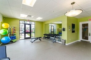 A gym with exercise equipment, a bench, and a mirror on the wall. - Fs9756ha - Storey Lake Resort - 4 Bed 3 Baths Townhouse (Kissimmee)