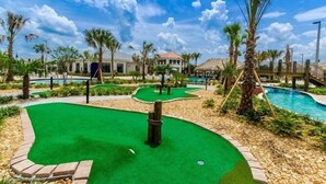 A golf course with a putting green, a pool, and palm trees. - Fs9765ha - Storey Lake Resort - 9 Bed 5 Baths Villa (Kissimmee)