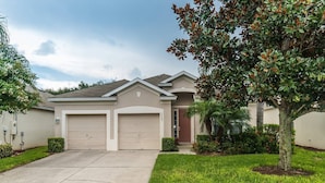 A single-story house with two attached garages, a front door, and a well-maintained lawn. - Grh9295ha - Windsor Hills Resort - 3 Bed 3 Baths Villa (Kissimmee)