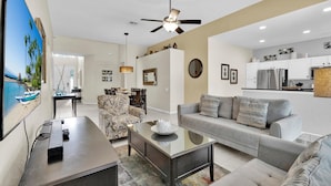 A modern living room with a sofa, coffee table, and a dining area with chairs. - Grh9296ha - Windsor Hills Resort - 5 Bed 5 Baths Villa (Kissimmee)