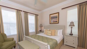 A bedroom with a bed, nightstands, a chair, and a bench.