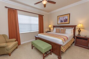 A bedroom with a bed, a chair, a bench, two bedside tables with lamps, a ceiling fan, and a window with curtains. - Fsv10255ha - Reunion Resort - 4 Bed 3.5 Baths Townhome (Kissimmee)