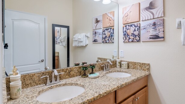 A bathroom with two sinks, a mirror, and artwork on the wall. - Grh10334ha - Paradise Palms Resort - 5 Bed 4 Baths Townhome (Kissimmee)