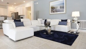A modern living room with a white sofa set, a glass coffee table, and a dark blue rug. - Fs10375ha - Watersong - 6 Bed 5.5 Baths Villa (Davenport)