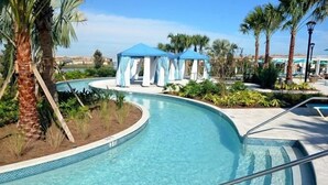 A swimming pool with a curved design, surrounded by palm trees and a gazebo structure. - Fs10524ha - Windsor At Westside Resort - 7 Bed 6 Baths Villa (Kissimmee)