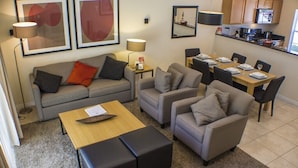 A modern living room with a sofa, two armchairs, a coffee table, and a dining area with a table set for four. - Ihr11318ha - Encantada Resort - 2 Bed 2.5 Baths Townhouse (Kissimmee)