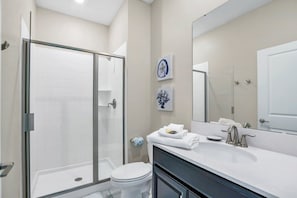 A modern bathroom with a glass-enclosed shower, a white toilet, and a vanity with a large mirror. - Fs11328ha - Storey Lake Resort - 4 Bed 3 Baths Townhouse (Kissimmee)