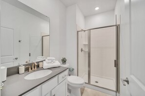 A modern bathroom with a glass-enclosed shower, a white sink, and a large mirror. - Fs11331ha - Storey Lake Resort - 4 Bed 3 Baths Townhouse (Kissimmee)