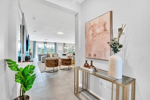 En moderne stue med en sofa, et sofabord og et stort abstrakt maleri.