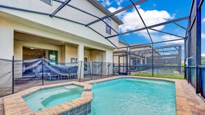 A swimming pool with a brick edge, surrounded by a covered patio area with chairs and a table. - Fs11374ha - Windsor At Westside Resort - 7 Bed 6 Baths Villa (Kissimmee)