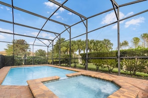 Piscina com vista desobstruída da paisagem ao redor, cercada por uma grade de metal.