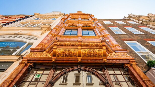 Un edificio con detalles arquitectónicos ornamentales, incluyendo un arco destacado y adornos decorativos.