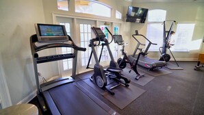A gym with treadmills, elliptical machines, and a stationary bike. - Grh14421ha - Emerald Island Resort - 5 Bed 3 Baths Villa (Kissimmee)