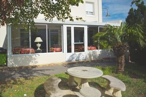 Ein Gebäude mit großen Fenstern und einer überdachten Terrasse.