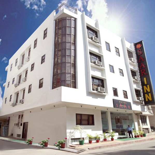A modern hotel with a prominent 'Saar' sign, multiple balconies, and a clear sky. - Hotel Saar Inn (New Delhi)